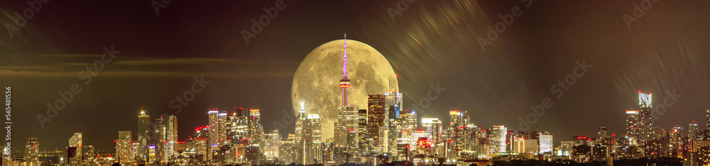 Full moon over Toronto at night. Toronto, Ontario, Canada skyline and moonlight of full moon. Cityscape with rising moon over GTA center. Great Toronto Area night city view.